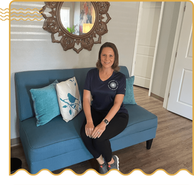 A woman sitting on top of a blue couch.