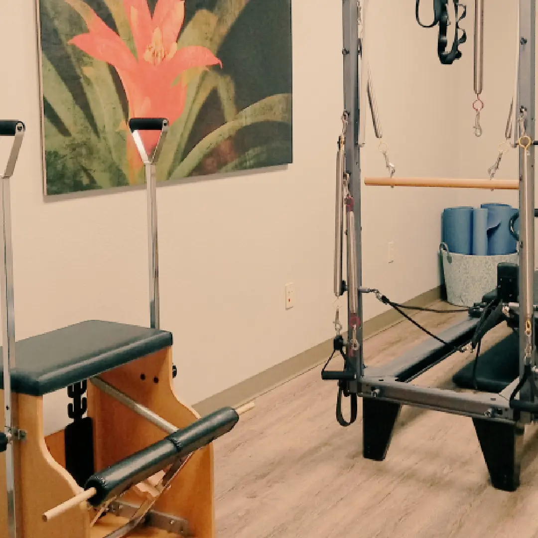 A room with two different types of pilates equipment.