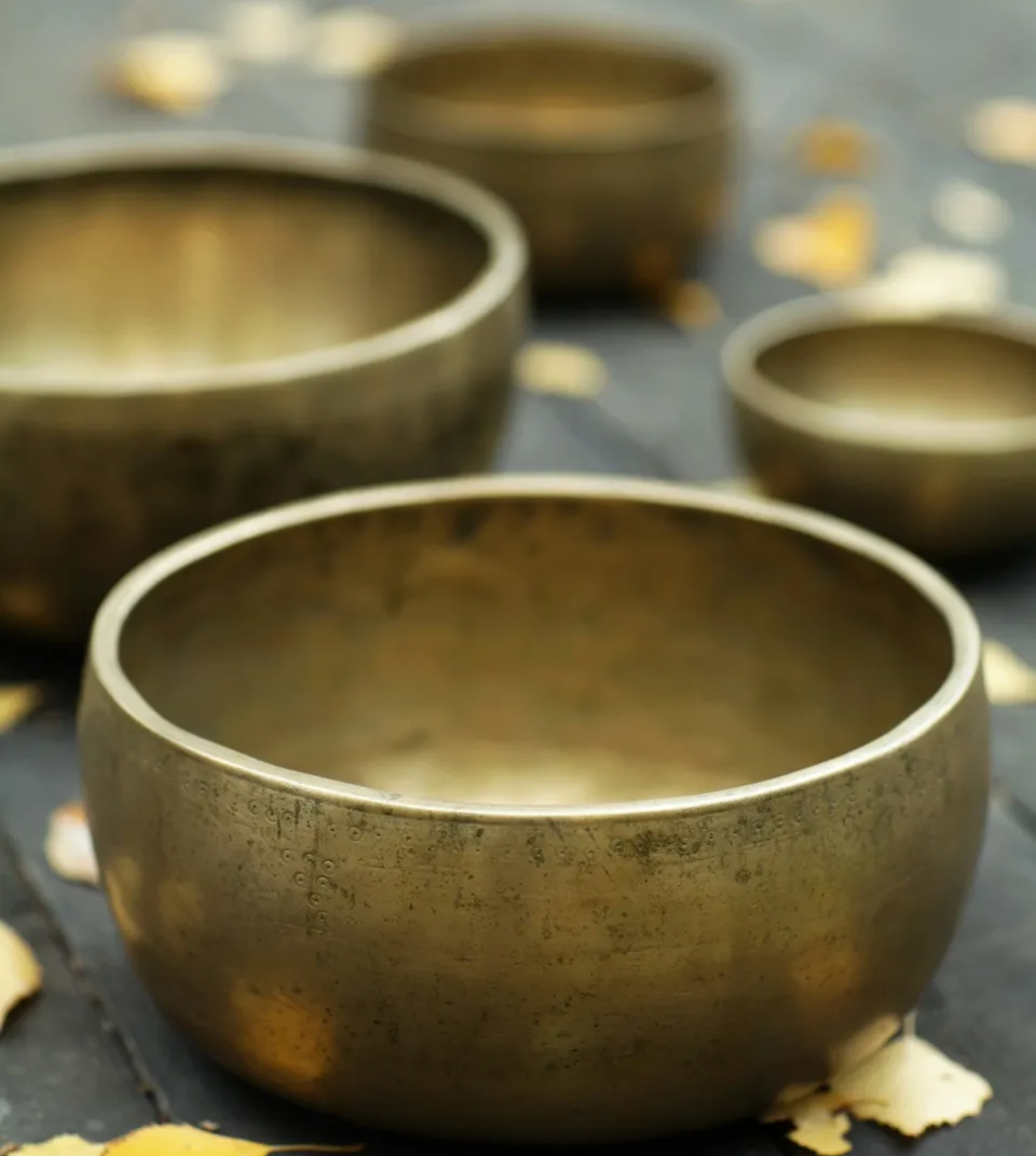 A group of brass bowls sitting on top of a table.